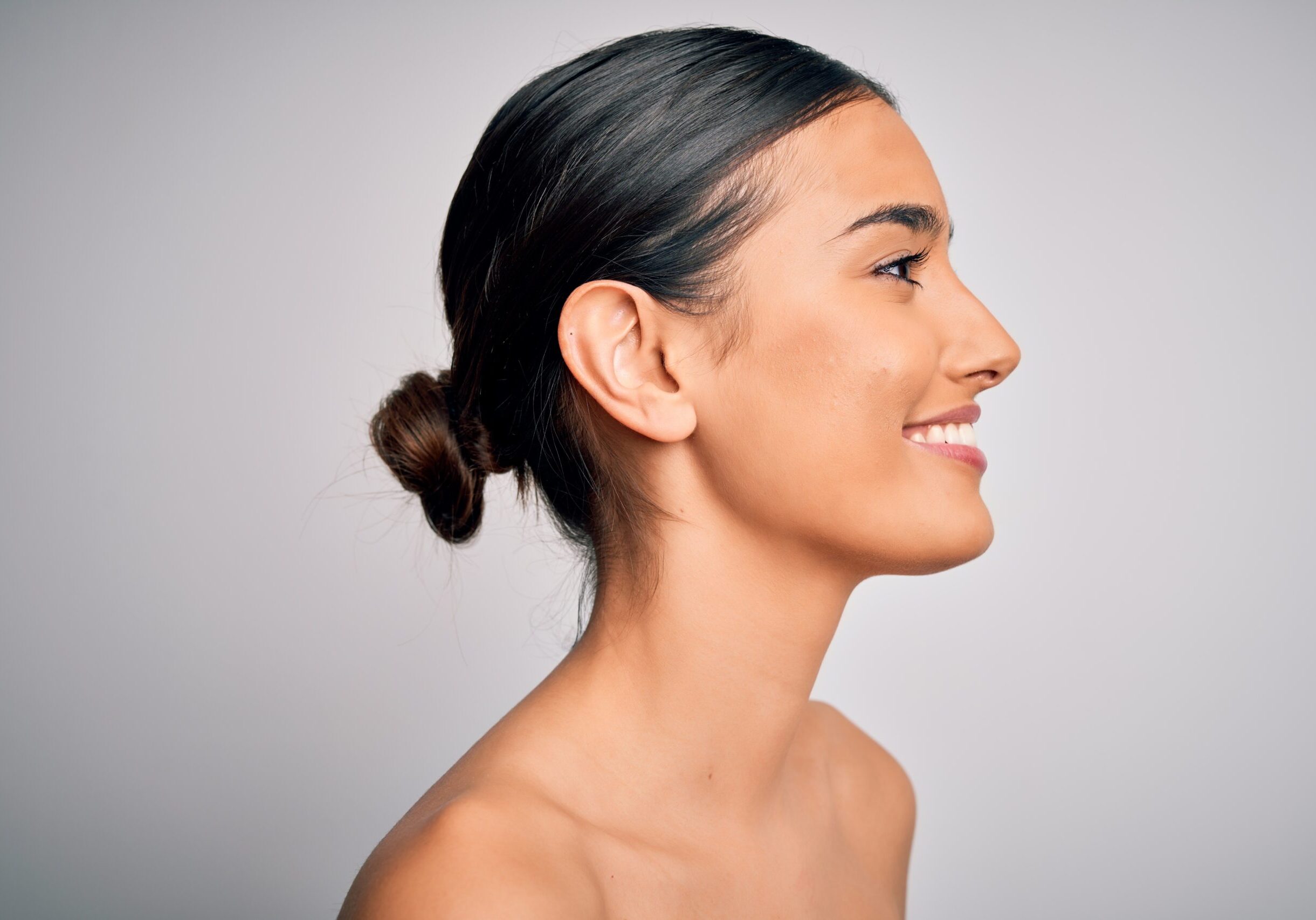 Close up of young beautiful woman with clear and pure skin. Perfect and clean skincare wearing natural makeup. Smiling happy looking fresh and healthy.